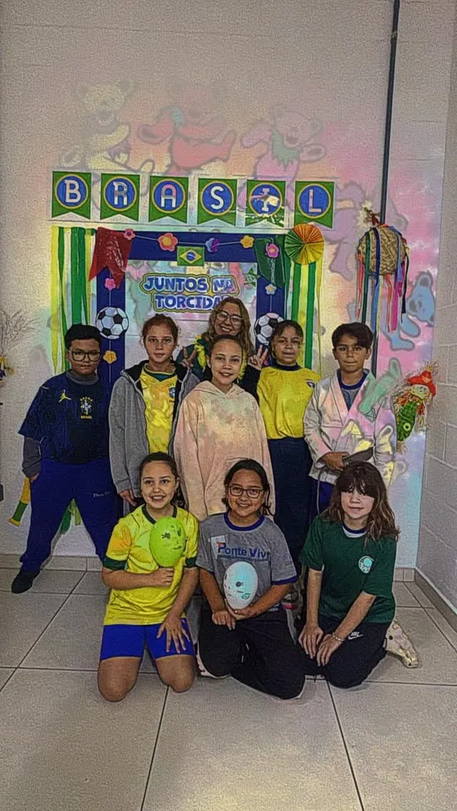 Turma reunida em frente a um painel decorado pelos alunos